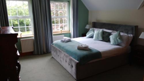a bedroom with a bed with two bags on it at Tullynacrunat Lodge in Castleblayney