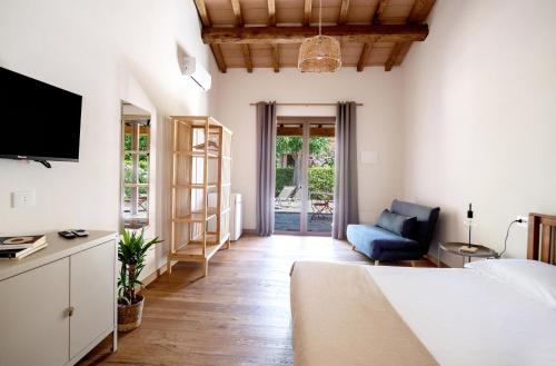 a room with a bed and a couch and a tv at Agriturismo La Sassicaia in Castiglione della Pescaia