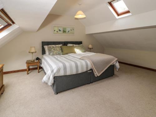 Un dormitorio con una cama grande en un ático. en Pennant Tigi Uchaf, en Dolgellau