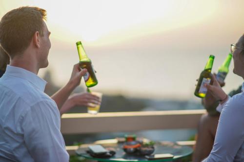 a group of people sitting around a table holding beer bottles at Gefinor Rotana &ndash; Beirut in Beirut