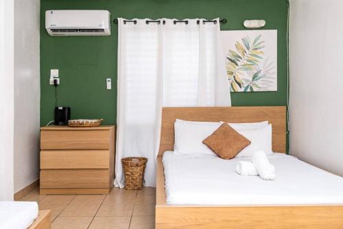 a bedroom with a bed with a green wall at Casamares Oasis Vacacional con Piscina y Barbacoa in Cabo Rojo