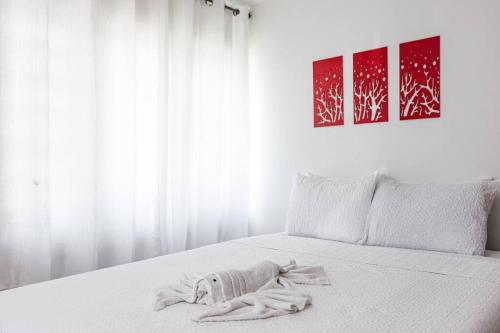 a white bed with a blanket on top of it at Casamares Oasis Vacacional con Piscina y Barbacoa in Cabo Rojo