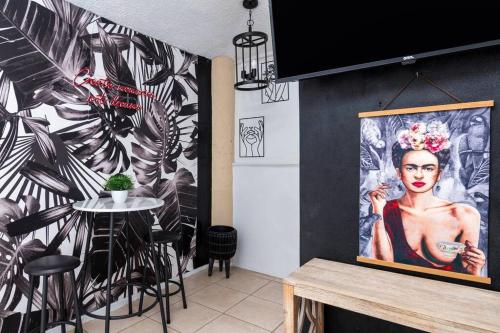 a room with a table and a painting of a woman at Casamares Oasis Vacacional con Piscina y Barbacoa in Cabo Rojo
