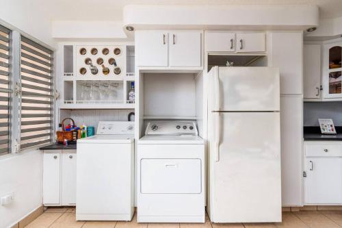 a kitchen with white cabinets and a white refrigerator at Casamares Oasis Vacacional con Piscina y Barbacoa in Cabo Rojo