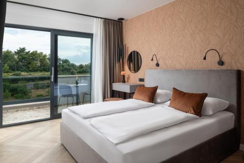 a bedroom with a large white bed and a large window at Luxury Villa David 2 heated pool in Podstrana