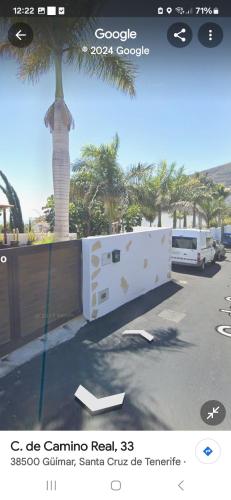 a picture of a fence with a palm tree in the background at Las palmeras B in Güimar