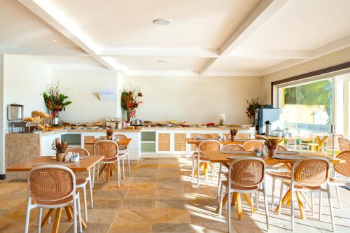a restaurant with tables and chairs and a counter at Uni Boutique Hotel & Spa in Búzios