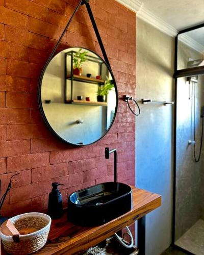 a bathroom with a black sink and a mirror at Quarto dos Vinhos in São Roque