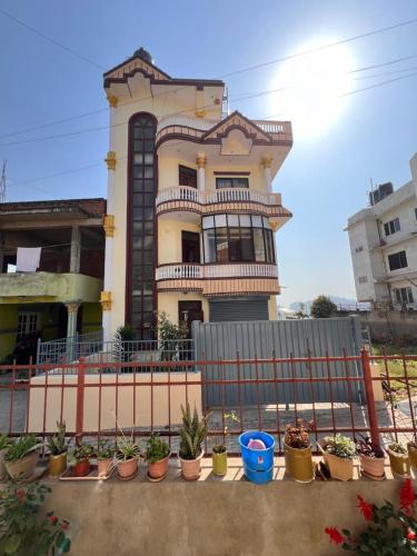 a building with potted plants in front of a fence at Kathmandu Valley View Homestay in Kathmandu