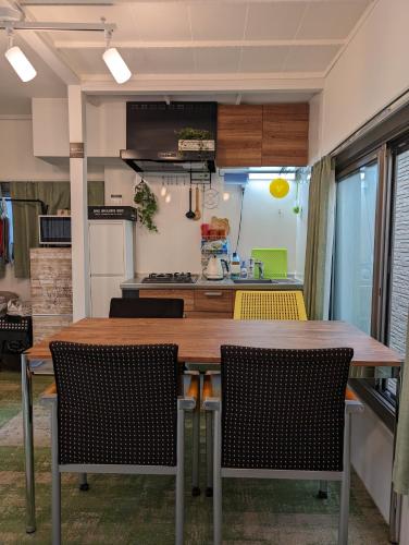 a kitchen with a wooden table and chairs at UMIBE Apartment in Tokyo