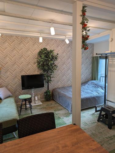 a living room with two beds and a tv at UMIBE Apartment in Tokyo