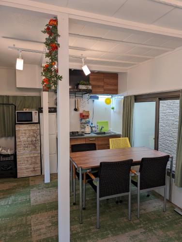 a kitchen and dining room with a wooden table and chairs at UMIBE Apartment in Tokyo