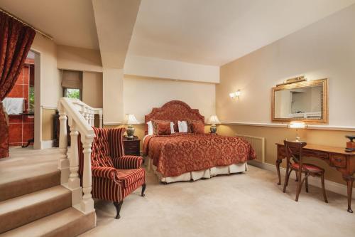a bedroom with a bed and a desk and a staircase at Lumley Castle Hotel in Chester-le-Street