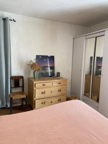 - une chambre avec un lit et une commode avec une télévision dans l'établissement BandB - les rosiers - Corse - Chambre Hellébore, à Conca