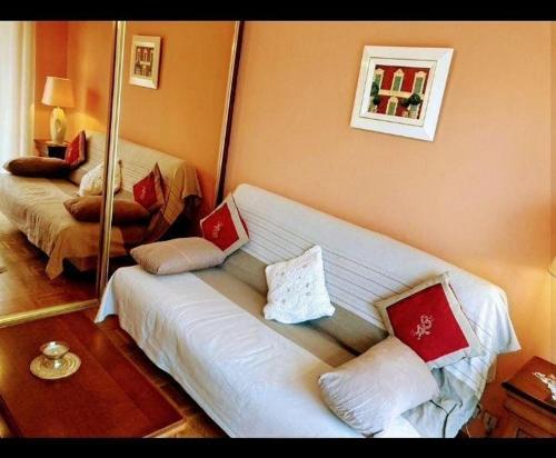 un salon avec un canapé blanc avec des oreillers dans l'établissement Un Jardin en Ville, à Nice