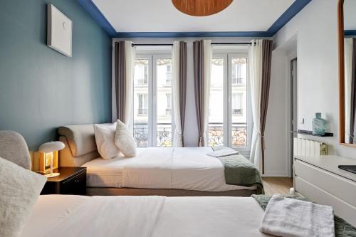 une chambre d'hôtel avec deux lits et un canapé dans l'établissement Élégance Urbaine - 2 chambres, à Paris