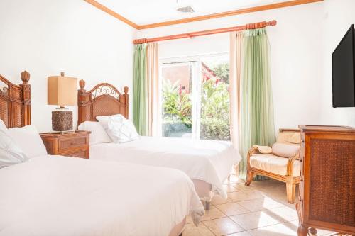 a bedroom with two beds and a window at Secluded Garden Paradise Condo @Los Sueños in Herradura