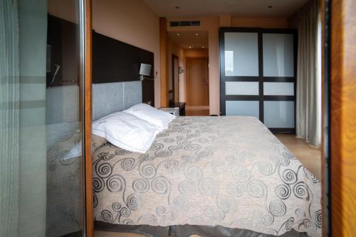 a bedroom with a large bed and a glass doorway at Hotel Felisa SPA in Queveda