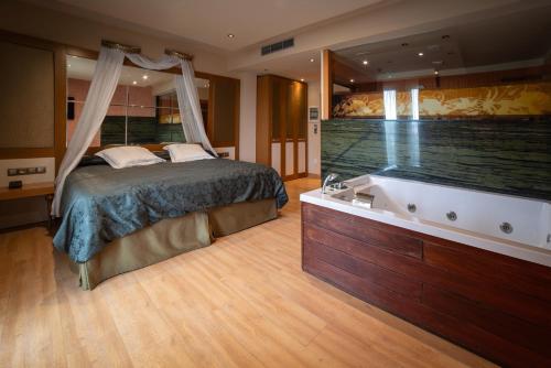 a bedroom with a bed and a bath tub at Hotel Felisa SPA in Queveda