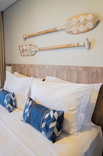 a bed with blue and white pillows and a baseball bat at Porto das Dunas Boutique Praia Hotel in Aquiraz