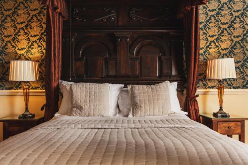 a bedroom with a large bed with two lamps at Lumley Castle Hotel in Chester-le-Street