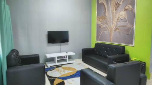 a living room with a couch and a flat screen tv at Saujana Homestay Perak in Seri Iskandar