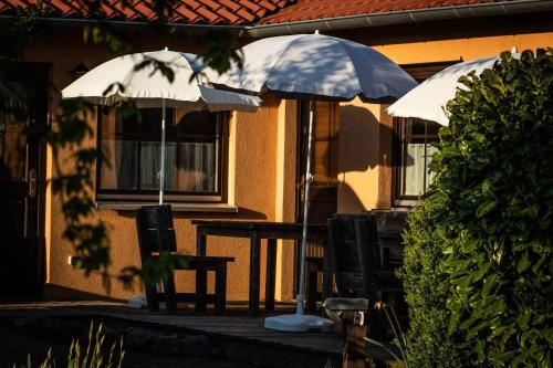 a table and two umbrellas in front of a building at Superior Doppelzimmer 1-2 Personen in Bastorf
