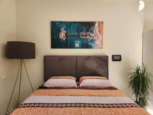 a bed in a bedroom with a picture on the wall at Porto Montenegro Luxury Studio Zeta in Tivat