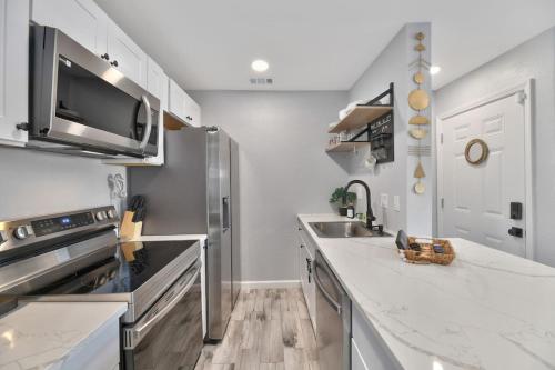 a kitchen with a sink and a stove top oven at Stay Awhile Condo Minutes to Beach with Pool in Galveston