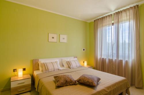 a bedroom with a bed with two pillows and a window at Apartments Karlo & Ivona in Labin