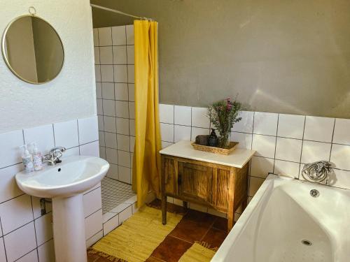 a bathroom with a sink and a mirror and a tub at Rondebossie Farm Retreat in Magoebaskloof