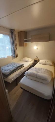 une chambre avec deux lits et une fenêtre dans l'établissement Mobil-home avec WIFI 6 à 8 couchages Domaine 4 étoiles au cœur des Châteaux de la Loire, à Onzain