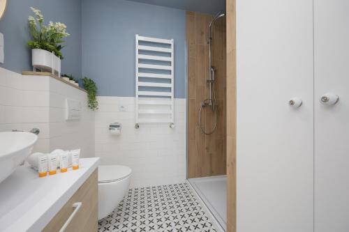 a bathroom with a toilet sink and a shower at Modern Apartments with Parking and AC Warsaw Suburbs by Noclegi Renters in Konstancin-Jeziorna