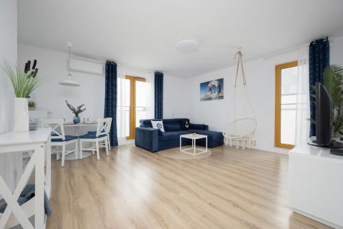 a living room with a blue couch and a table at Modern Apartments with Parking and AC Warsaw Suburbs by Noclegi Renters in Konstancin-Jeziorna