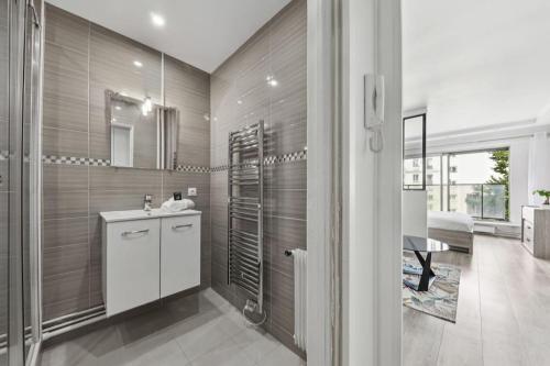 La salle de bains privative est pourvue d'un lavabo et d'une douche. dans l'établissement Appartement élégant et design, à Paris