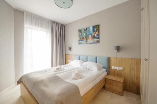 a bedroom with a bed with a clock on the wall at Apartamenty Akwamaryn in Ustka