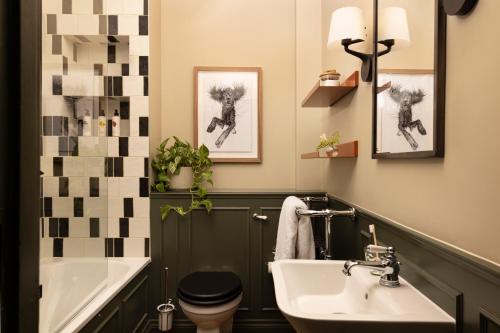 a bathroom with a sink and a toilet and a tub at New Park Manor Hotel - A Luxury Family Hotel in Brockenhurst