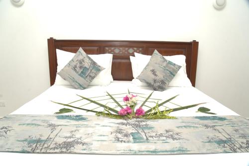 a bed with a flower arrangement on top of it at Alfa Boutique Hotel in Kiwengwa
