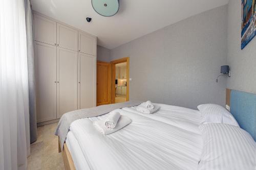 a bedroom with a white bed with two towels on it at Apartamenty Akwamaryn in Ustka