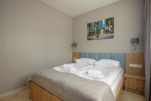 a bedroom with a bed with white sheets and pillows at Apartamenty Akwamaryn in Ustka