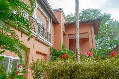 a pink building with plants in front of it at Secluded Garden Paradise Condo @Los Sueños in Herradura