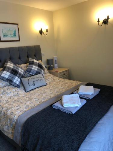 a bedroom with a bed with two towels on it at The Stowey Arms in Exminster