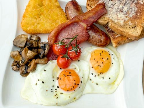 a white plate with eggs bacon mushrooms and toast at Quob Park Old House Hotel & Spa in Fareham