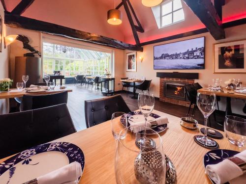 a dining room with a table and a fireplace at Quob Park Old House Hotel & Spa in Fareham