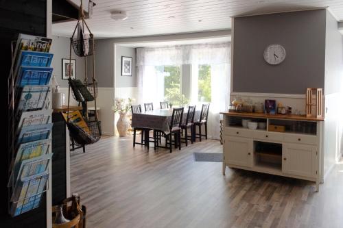 a living room with a table and a clock on the wall at Nalles Gästhem in Eckerö