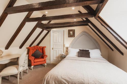 a bedroom with a white bed and an orange chair at Lumley Castle Hotel in Chester-le-Street