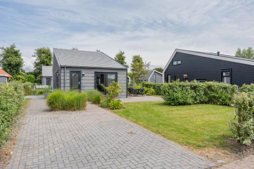 a house with a garden and a brick driveway at Beau Su Mer nr 1 in Kattendijke
