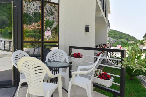 three white chairs and a table on a balcony at Apartments M Čanj in Čanj