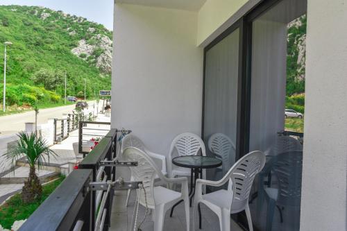 a row of white chairs and a table on a balcony at Apartments M Čanj in Čanj