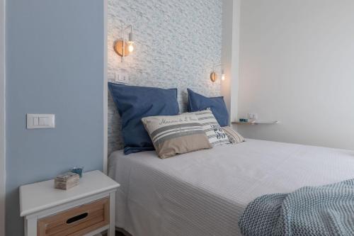 a bedroom with a white bed with blue pillows at Conero Suite in Marcelli